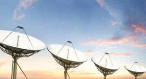 satellite dishes pointing at a sunset sky