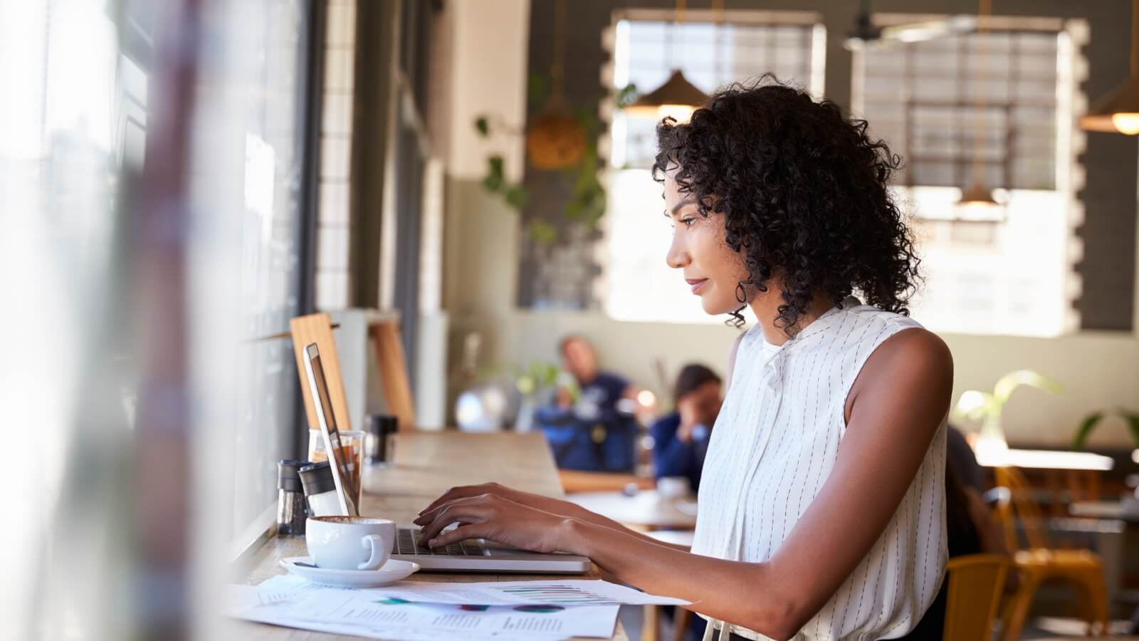 Businesswoman working on a laptop in a coffee shop.