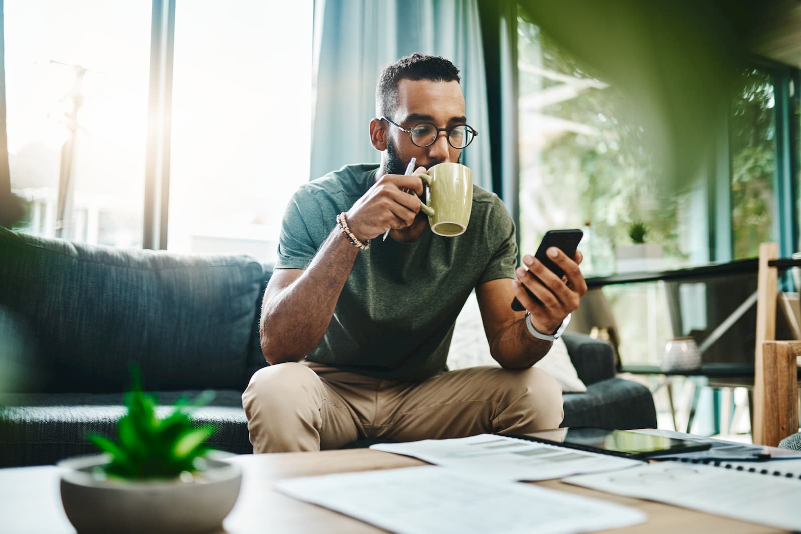 Man using a 5G phone while drinking his morning coffee