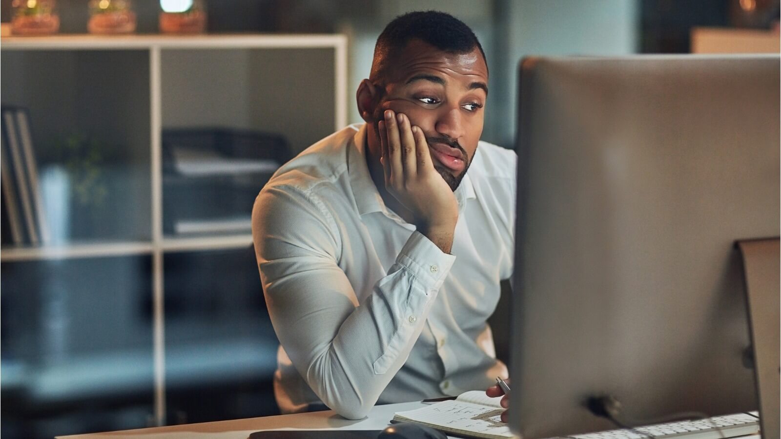 Man staring at computer screen with frustrated look