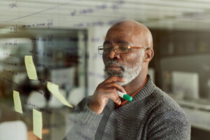 man with magic marker taking notes and making plans at window