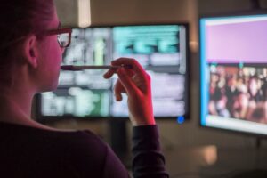 woman looking at computer screens in safety thanks to vpn