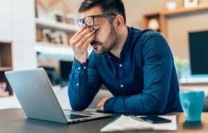 frustrated man sitting at his laptop