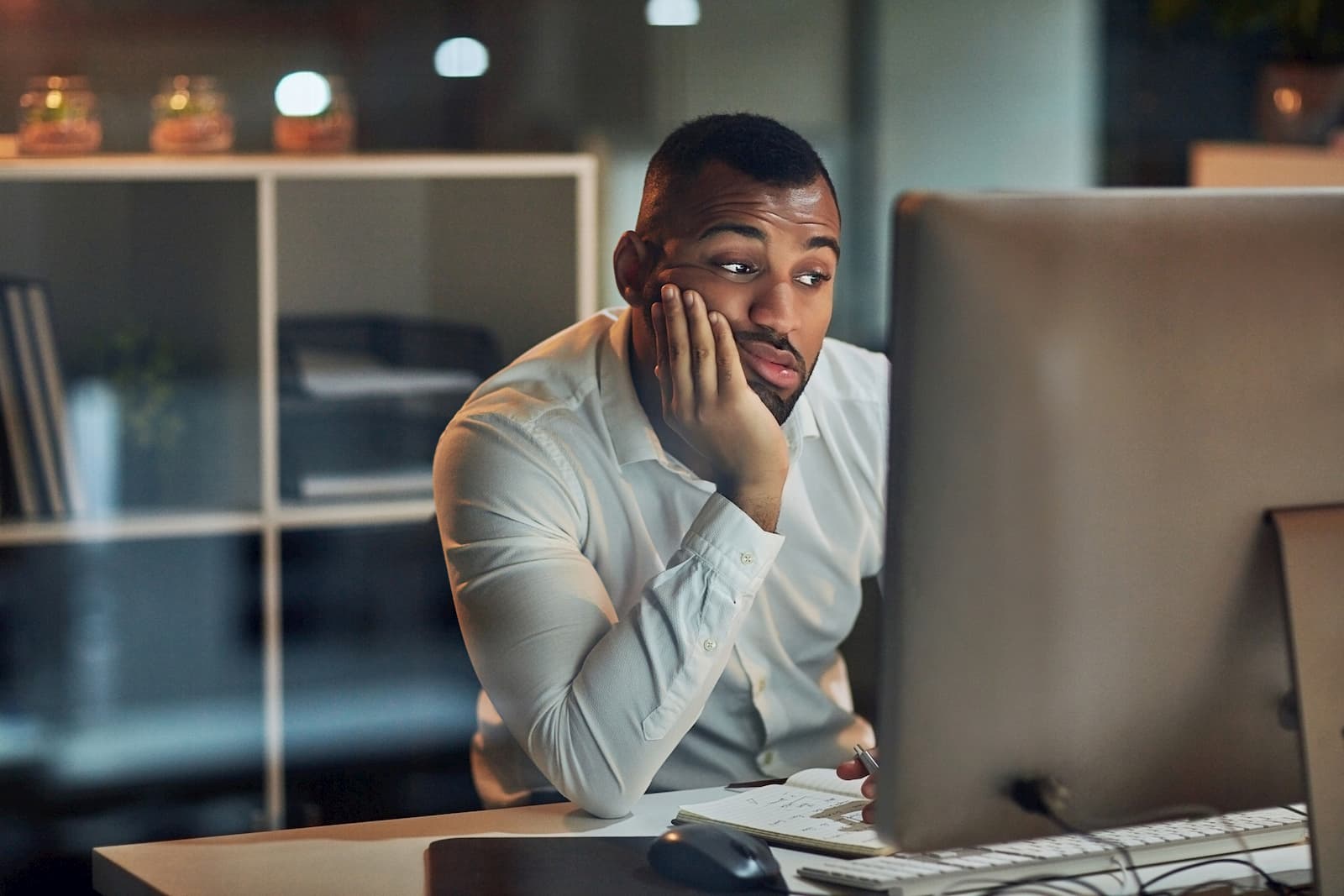 man sitting at a computer who is bored because the internet is slow