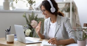 woman sitting at laptop computer with headphones on