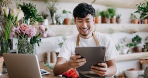 man in flower shop using wifi on tablet