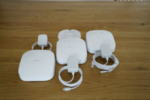 The three-pack kit includes three Eero Pro 6 units, three power adapters, and an Ethernet cable.
