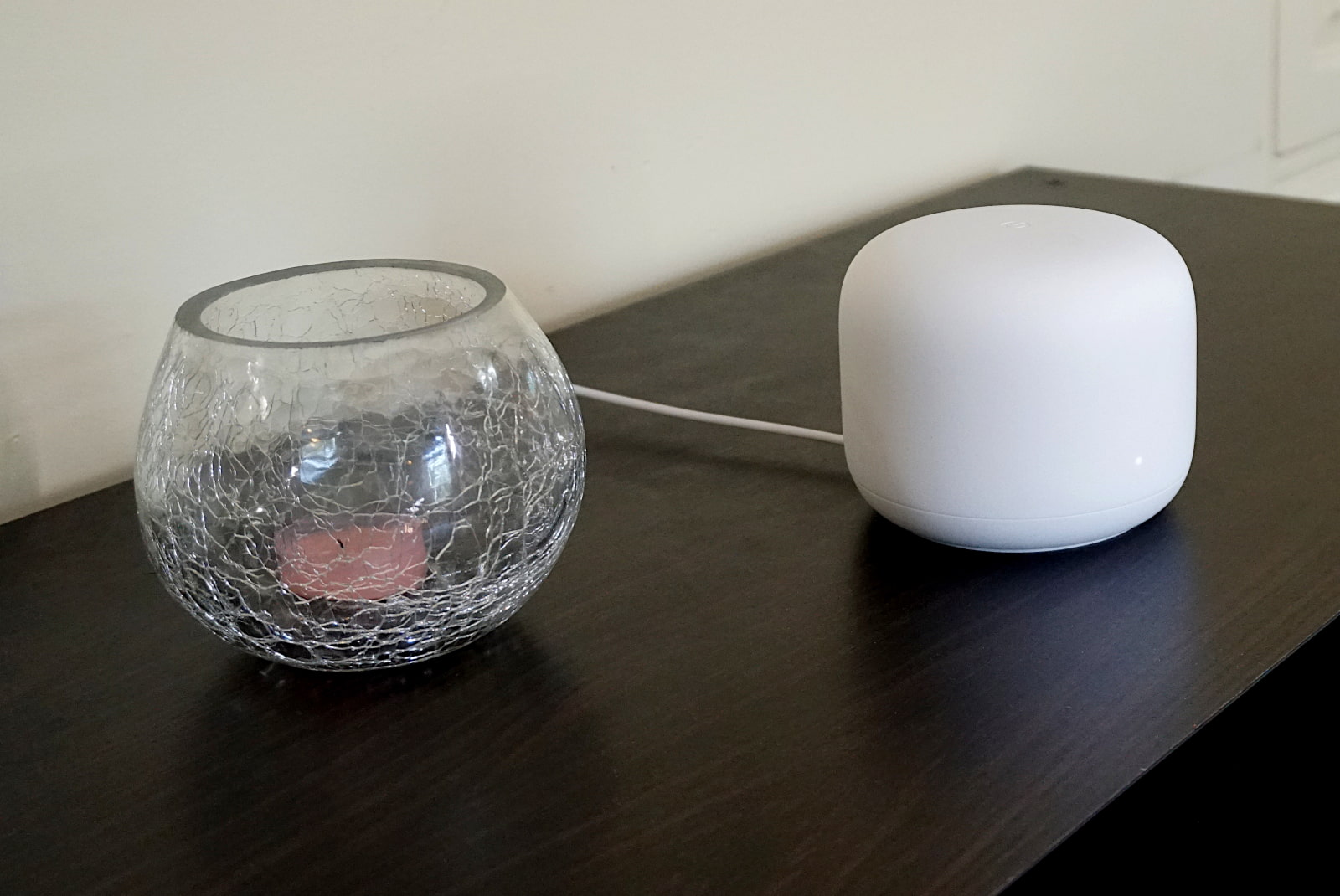 Google Nest Wifi on table next to glass bowl