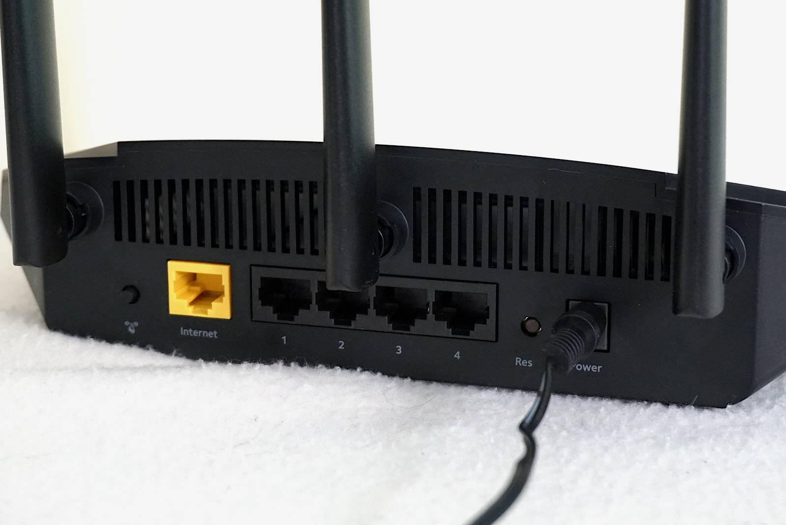 Rear of NETGEAR R6700AX router showing four LAN ports and one WAN port