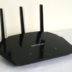 Side view of NETGEAR R6700AX router with illuminated lights