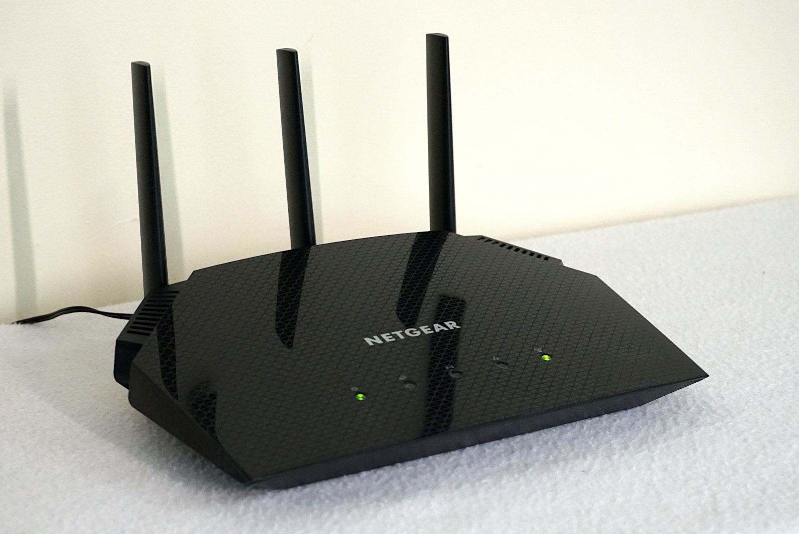 Side view of NETGEAR R6700AX router with illuminated lights