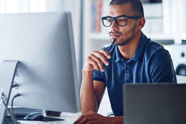 male looking at computer wearing glasses