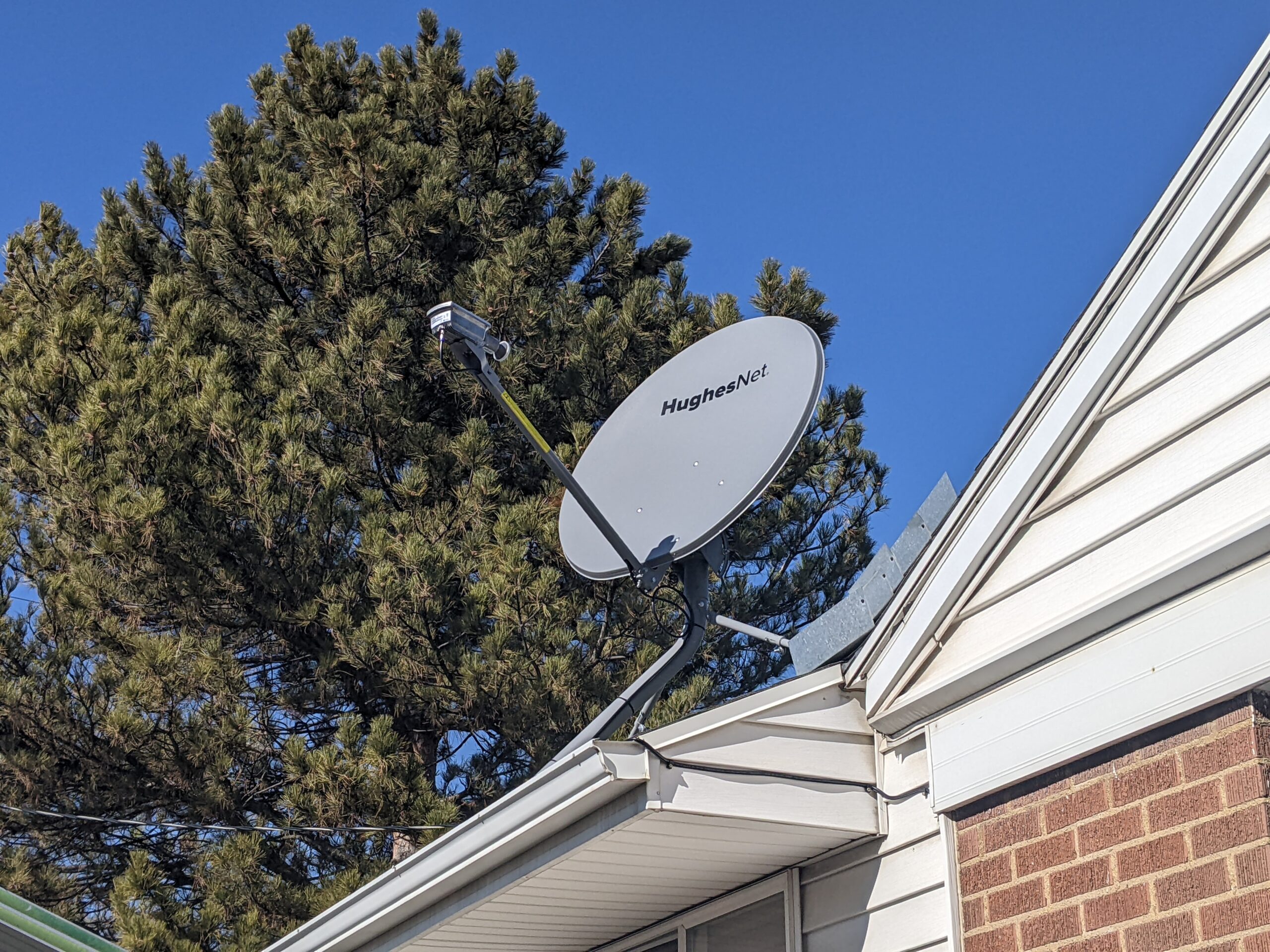 HughesNet satellite dish mounted on top of house