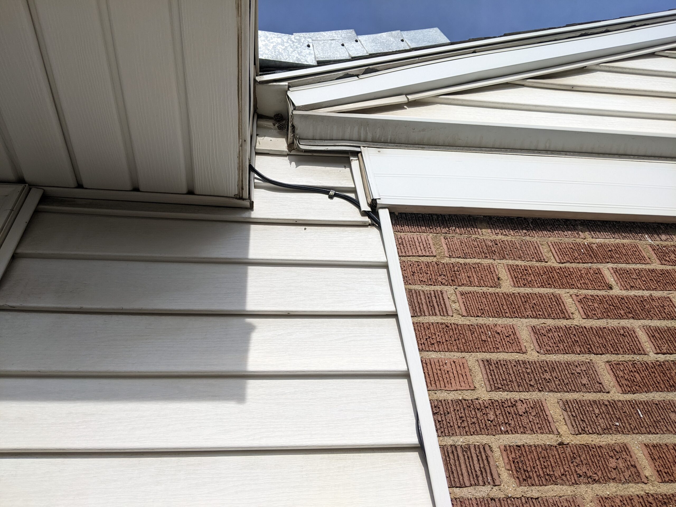 Exterior of house with HughesNet cable tucked along vinyl siding