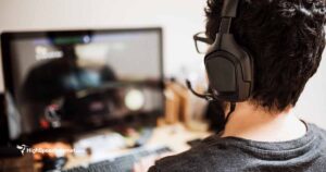 person gaming on computer hearing headset
