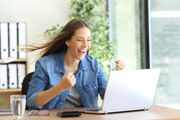 woman sitting in front of laptop excited about fast speeds