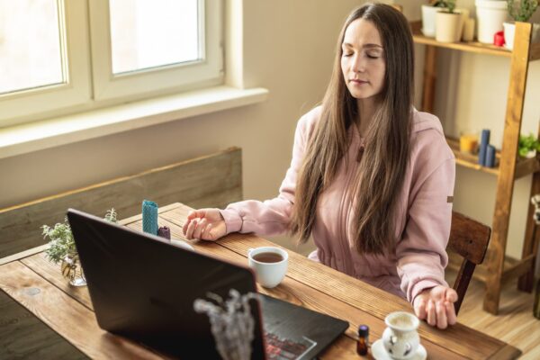 woman meditating while sitting at computer