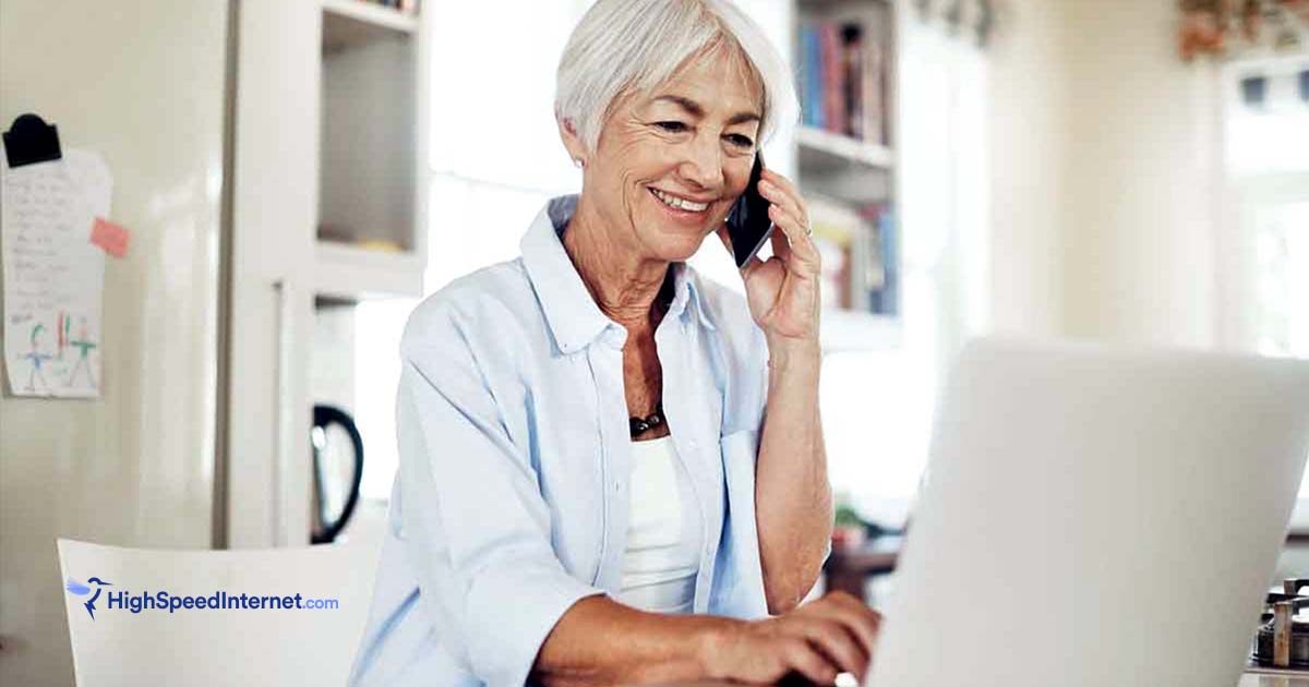 senior woman on phone using laptop