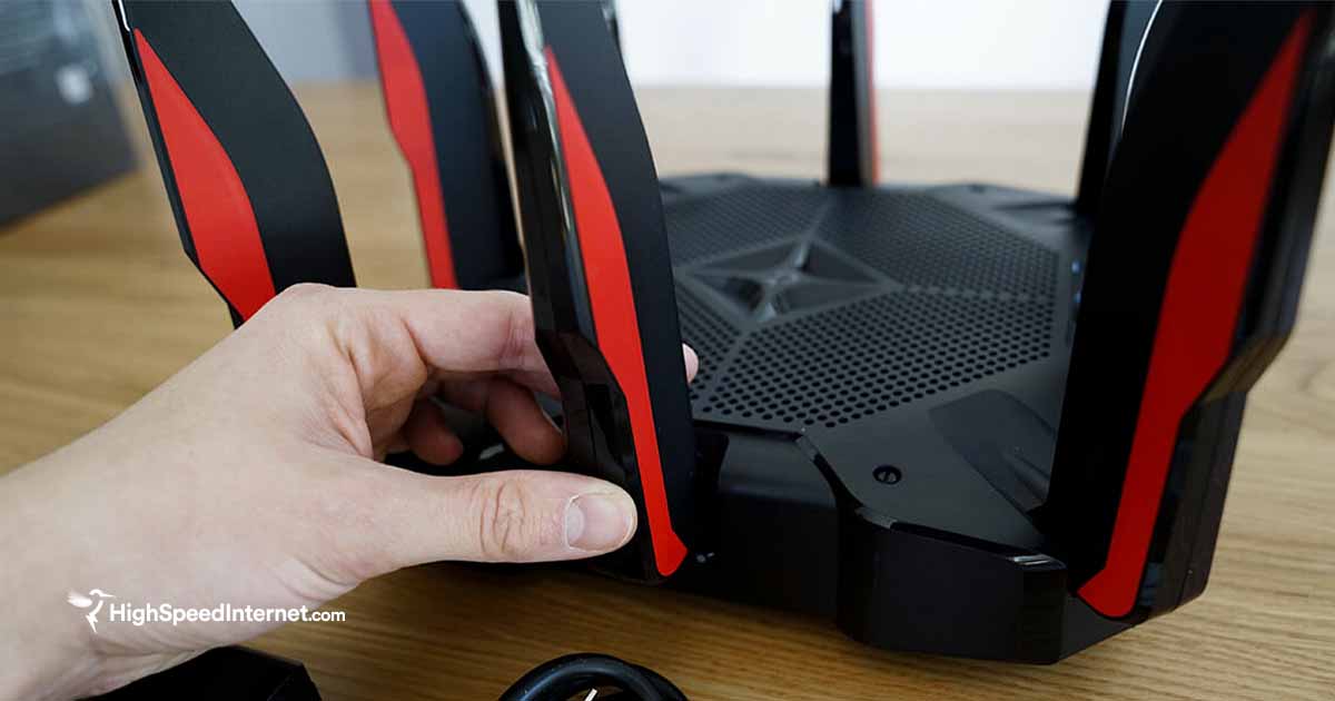 person adjusting an antenna on a wifi router