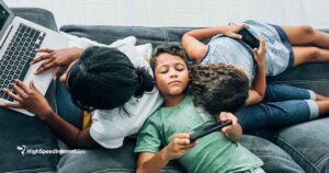 birds eye view of family on couch using multiple devices