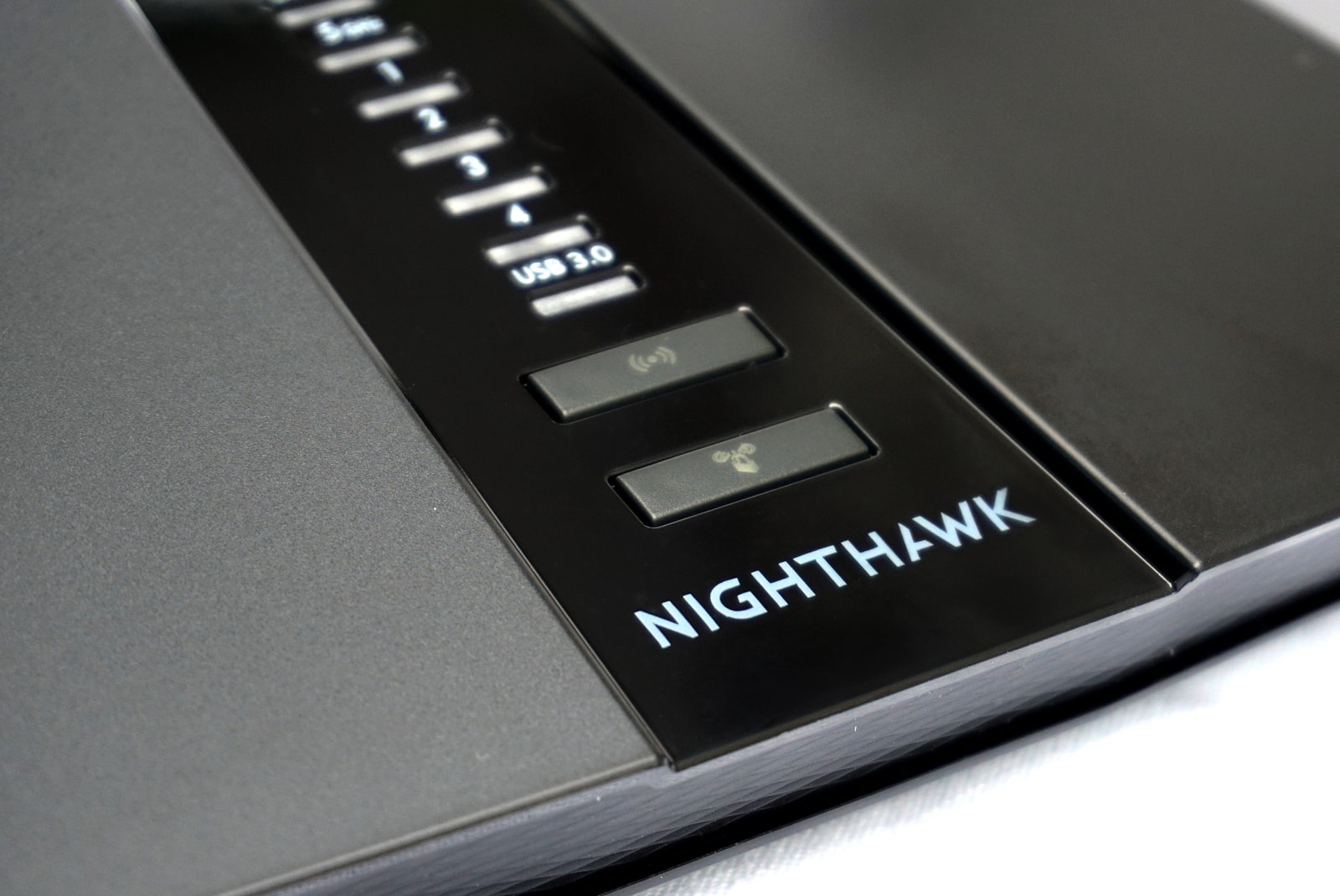netgear-nighthawk-rax50-logo Close up of front of router showing Nighthawk logo and buttons