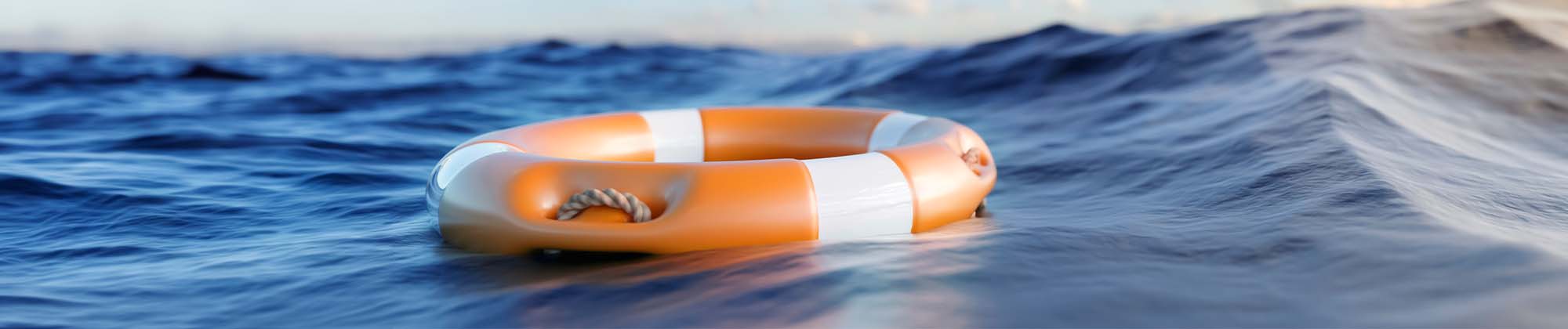 orange and white life raft floating in open water