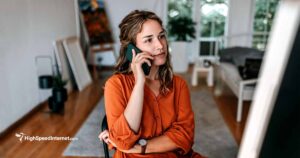 woman talking on phone while sitting at a computer