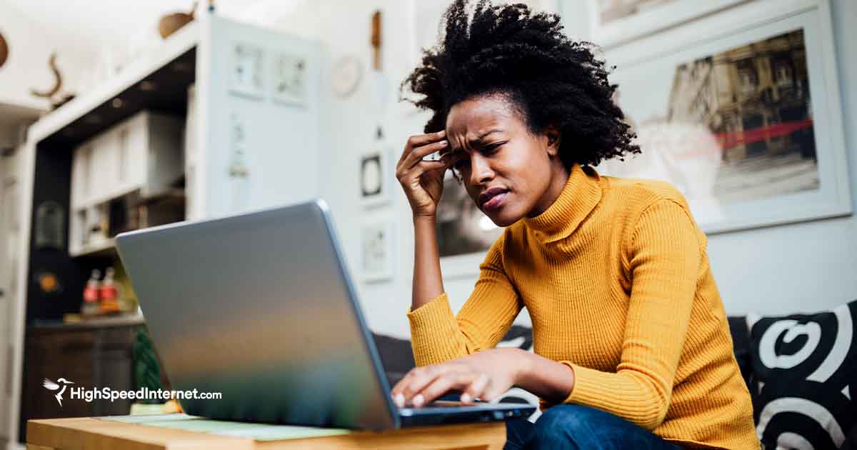 Woman appearing frustrated while looking at a laptop screen