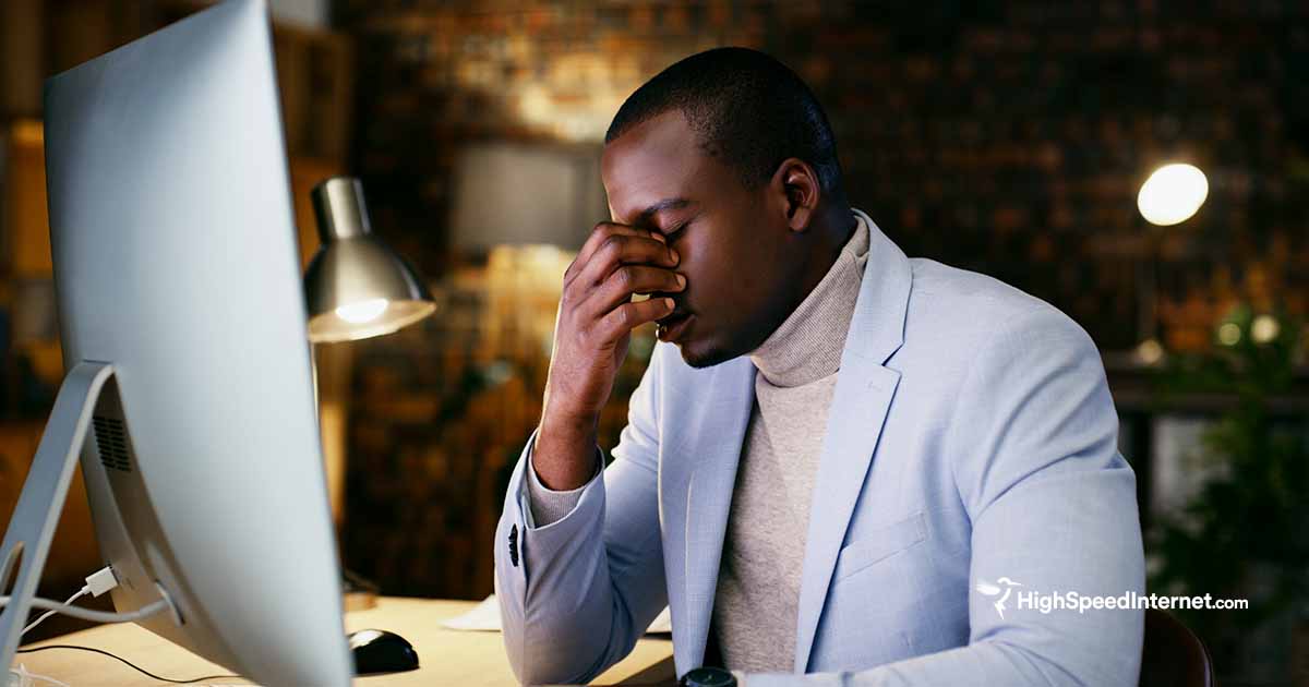 man in front of computer monitor looking frustrated