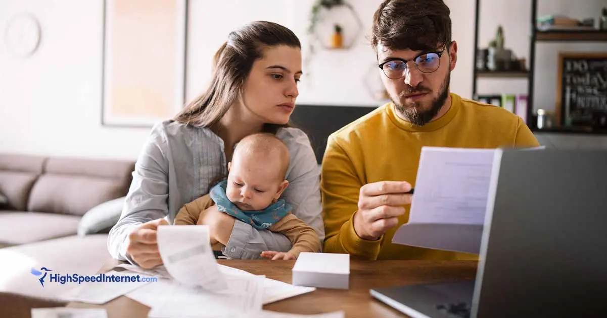 Couple holding a baby and looking at a paper