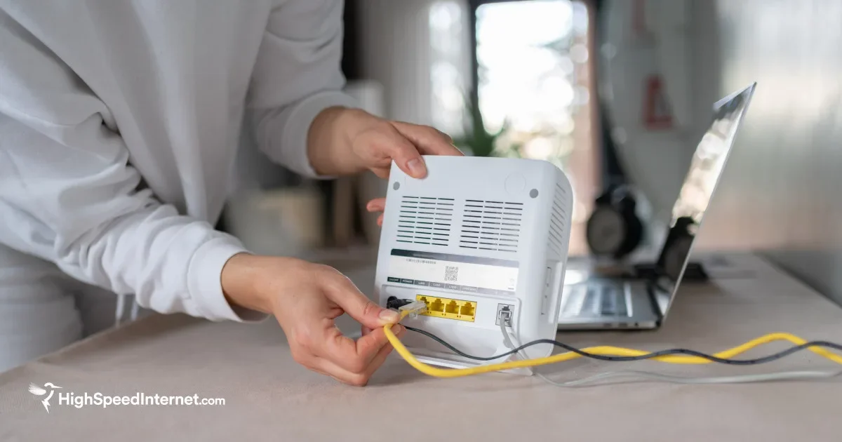 Person holding a router and plugging in cords