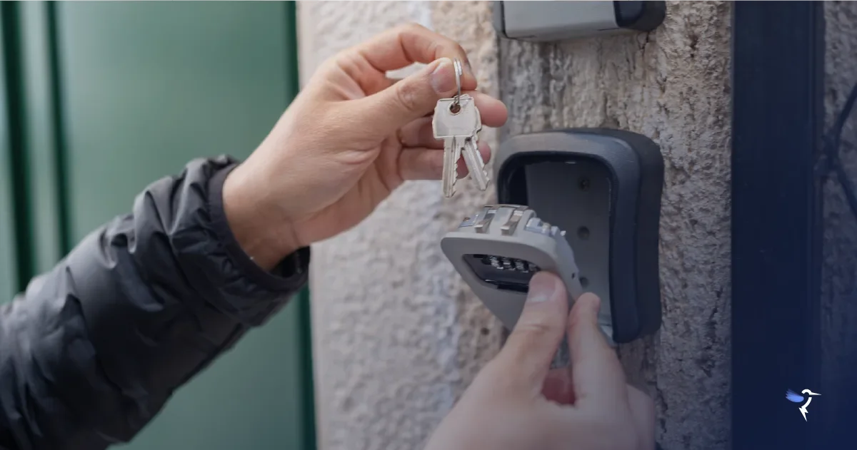 A person holding a set of keys above a lockbox